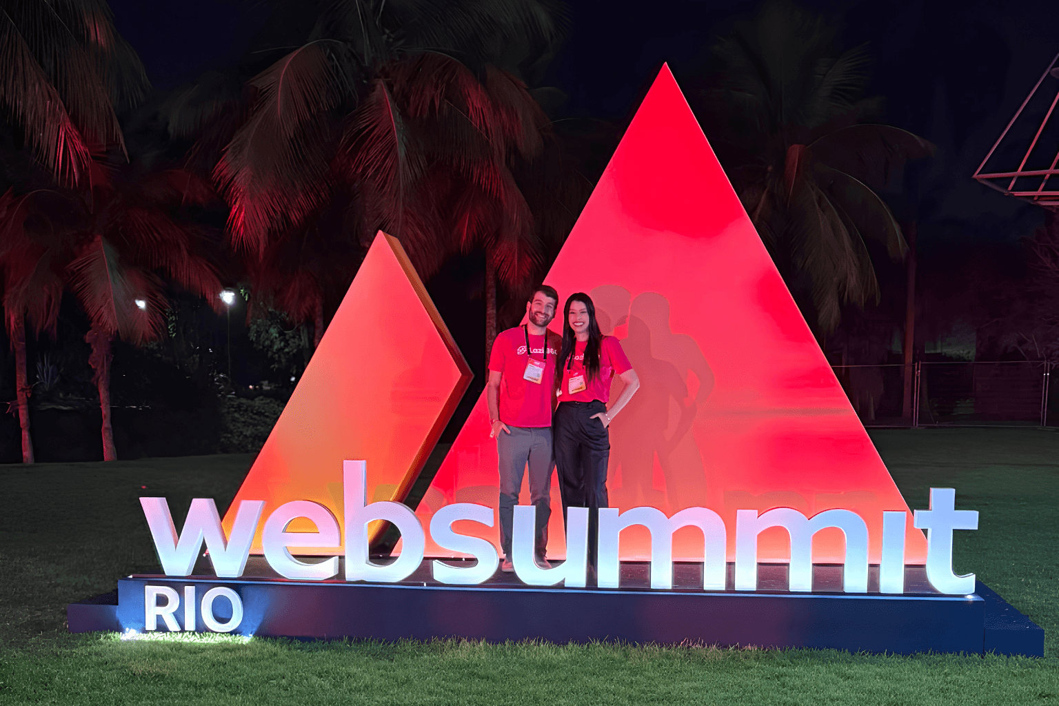Larissa Rocha e Pedro Huber, founders da Lazi 360, juntos no letreiro do Web Summit Rio