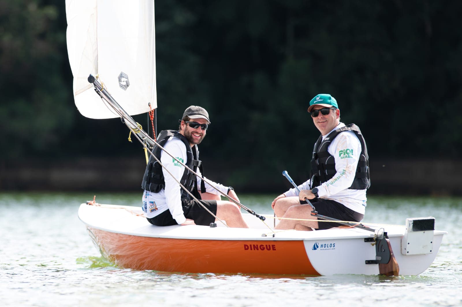Pedro Huber, COO da Lazi 360, e pai em um barco Dingue sorrindo para o fotógrafo na 4a Regata Festiva da 5a Edição do Mata Atlântica Eco Festival na represa do Passaúna em Araucária (Região Metropolitana de Curitiba)